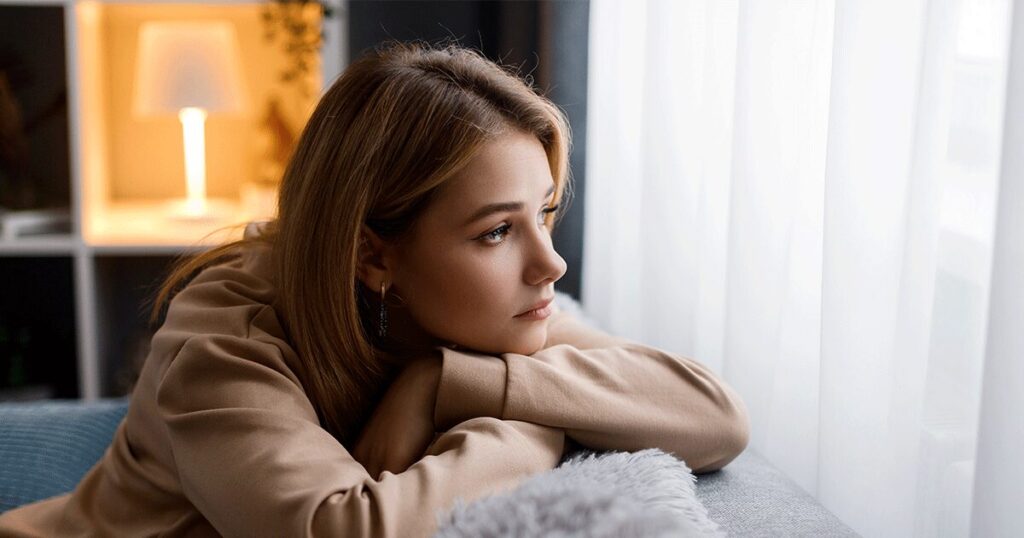 Woman looking out the window thinking about abortion